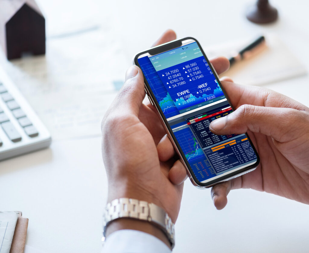 Hands holding smartphone displaying stock market trading app.
