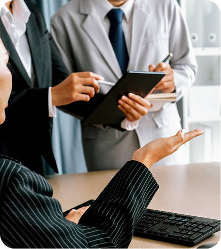 Business people discussing documents at an office desk.